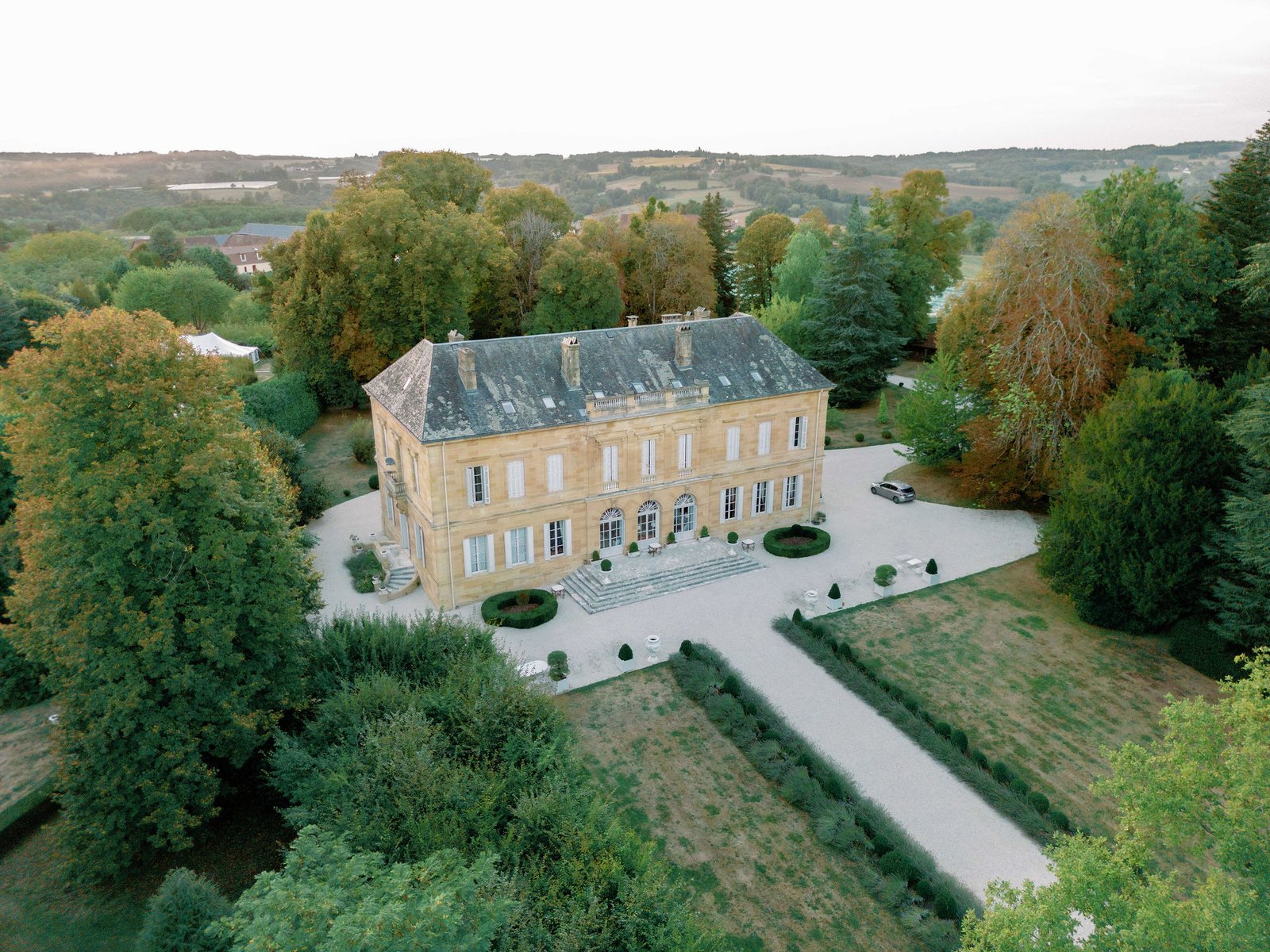 Aerial view of Château de la Durantie estate in the Dordogne countryside during golden autumn evening