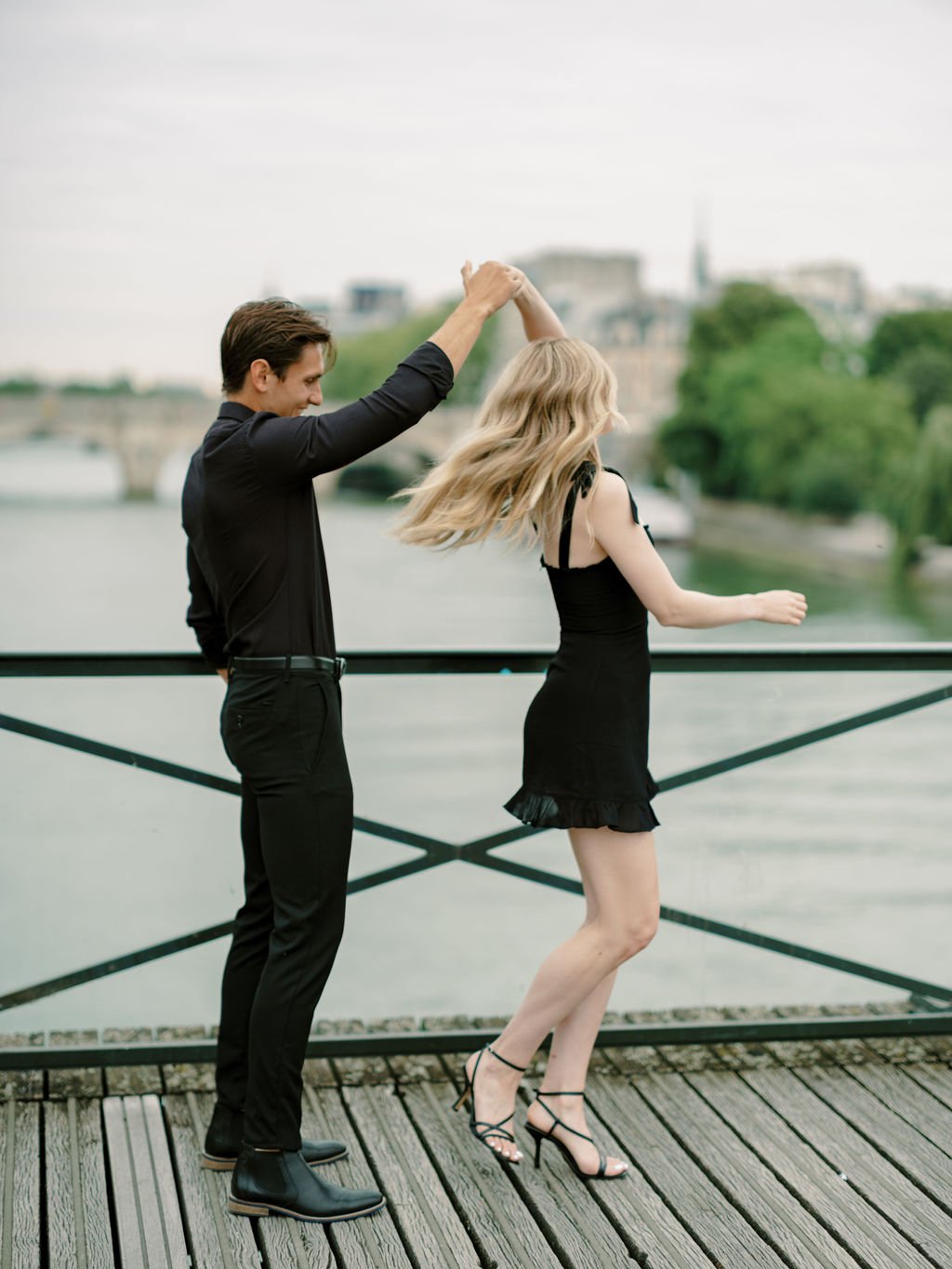 Couple dancing naturally on Pont des Arts during their engagement session in Paris