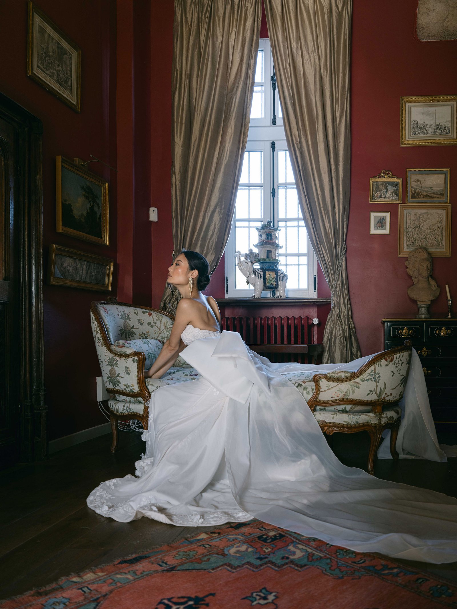 TOP 20 Wedding Photographers France 2026 editorial bridal portrait in silk ballgown on antique chaise at Manoir de Vacheresses