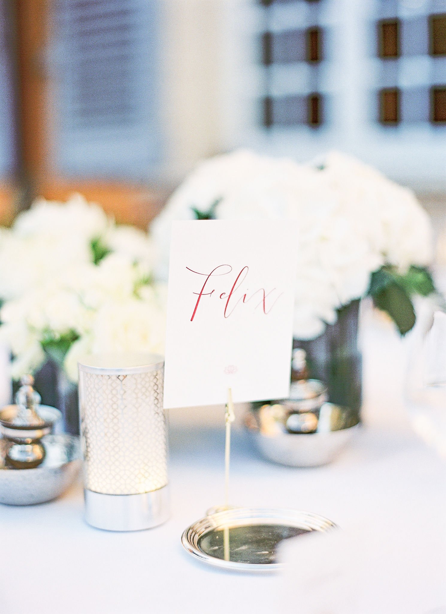 Elegant calligraphy table number with white hydrangeas at Pan Deï Palais Saint-Tropez reception in soft golden light