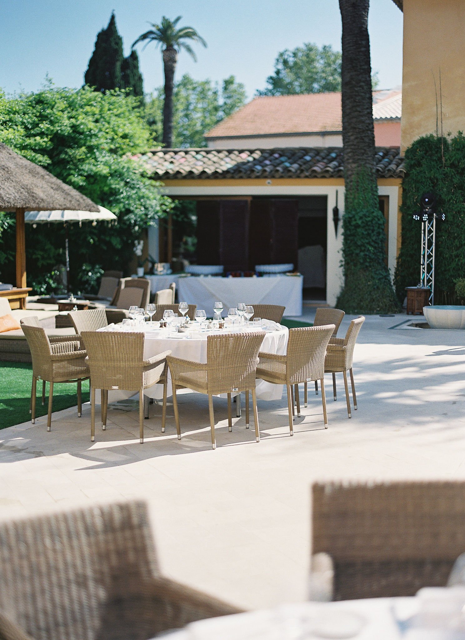 Elegant wicker dining setup on Mediterranean terrace at Pan Deï Palais Saint-Tropez in golden afternoon light