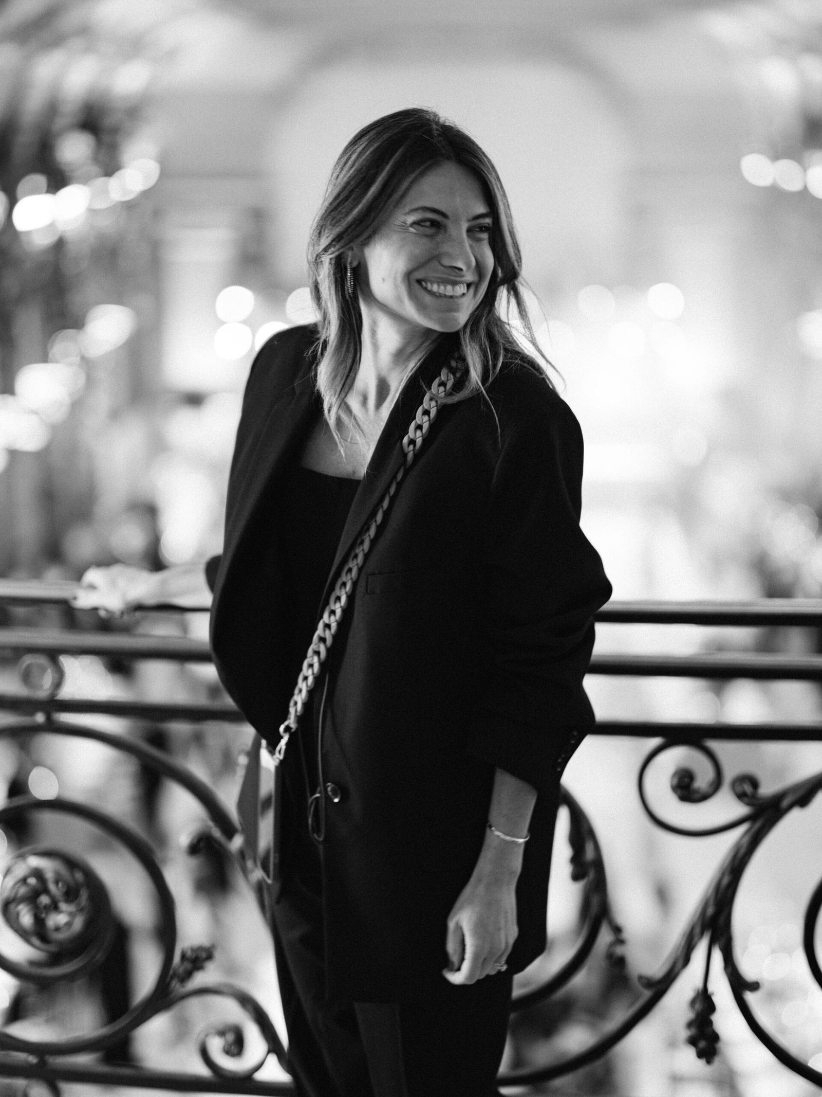 Paris palace guest portrait on ornate balcony with evening bokeh lights