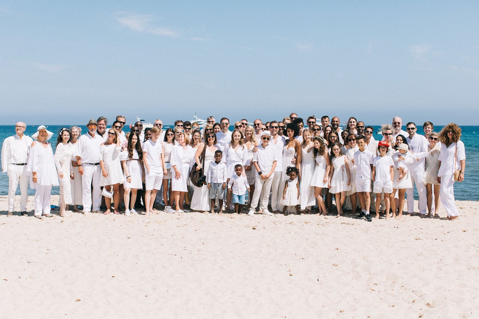 Family formals beach group portrait in all-white attire at Saint-Tropez during golden hour