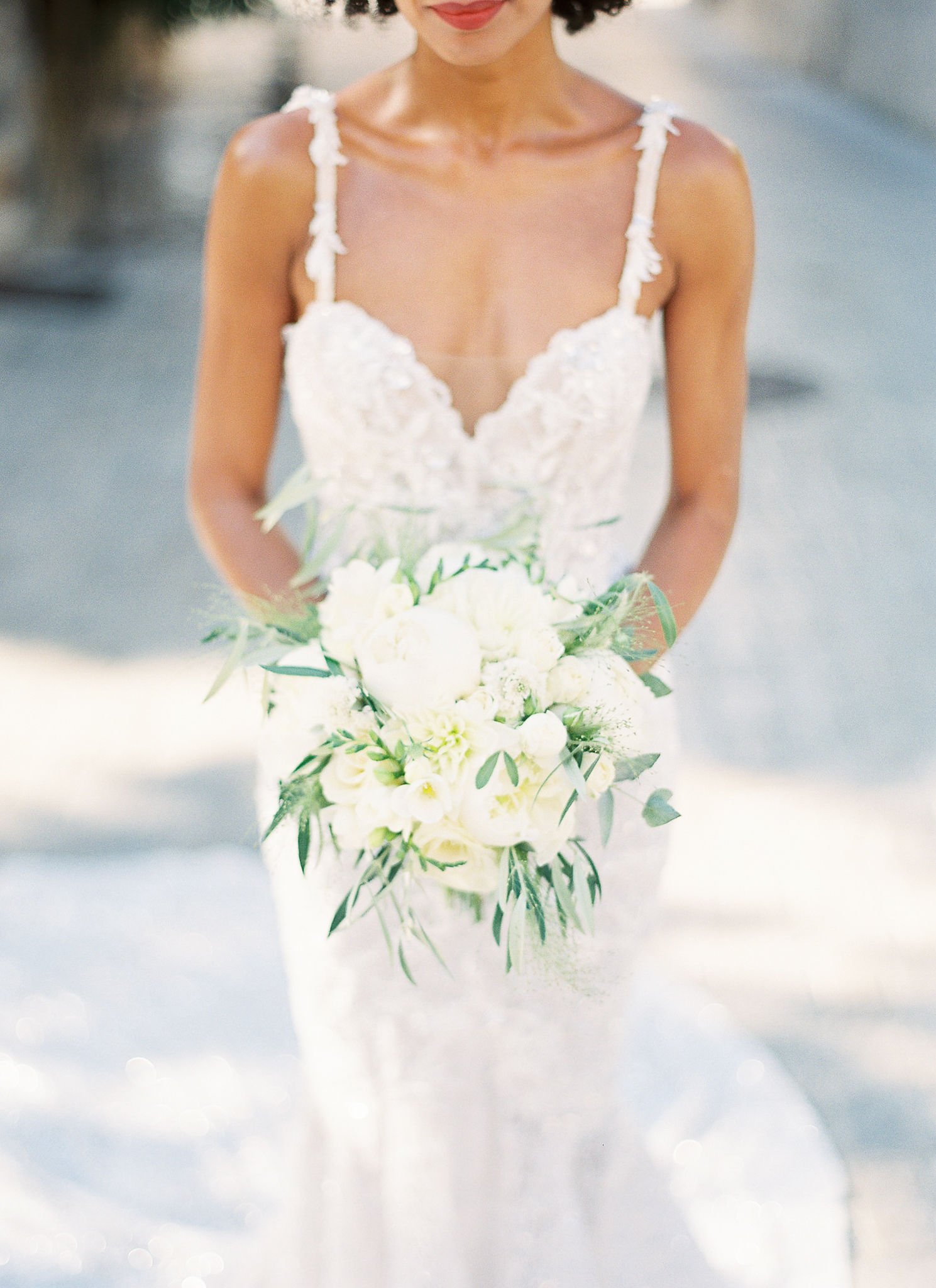 Bride in lace gown holding white peony bouquet at Pan Deï Palais Saint-Tropez in golden hour light