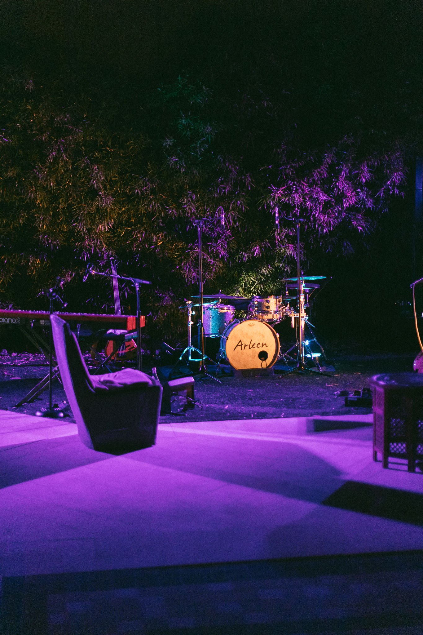 Live band stage setup with purple lighting at luxury Saint-Tropez wedding reception under evening trees