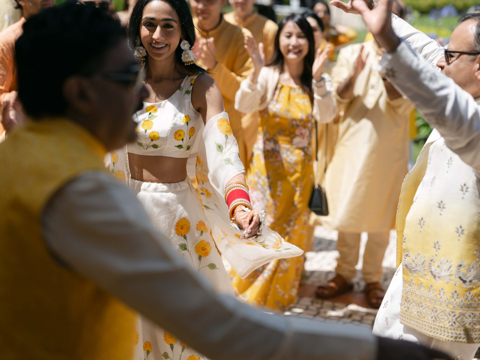 Haldi procession with the bride in a floral lehenga, sunlit and joyful, Indian wedding in Lisbon