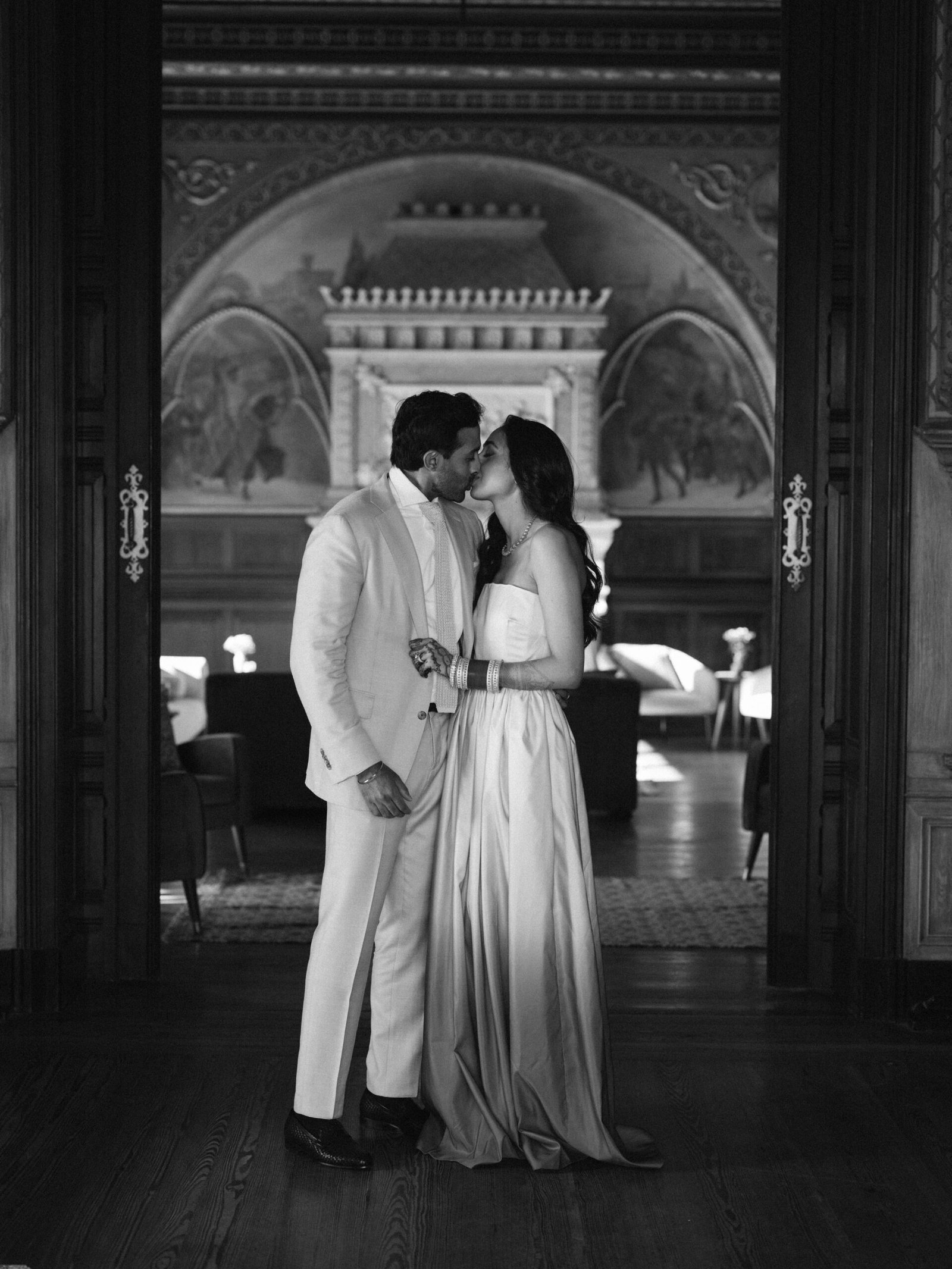 Couple kissing in the doorway of a frescoed hall in Lisbon, evening light