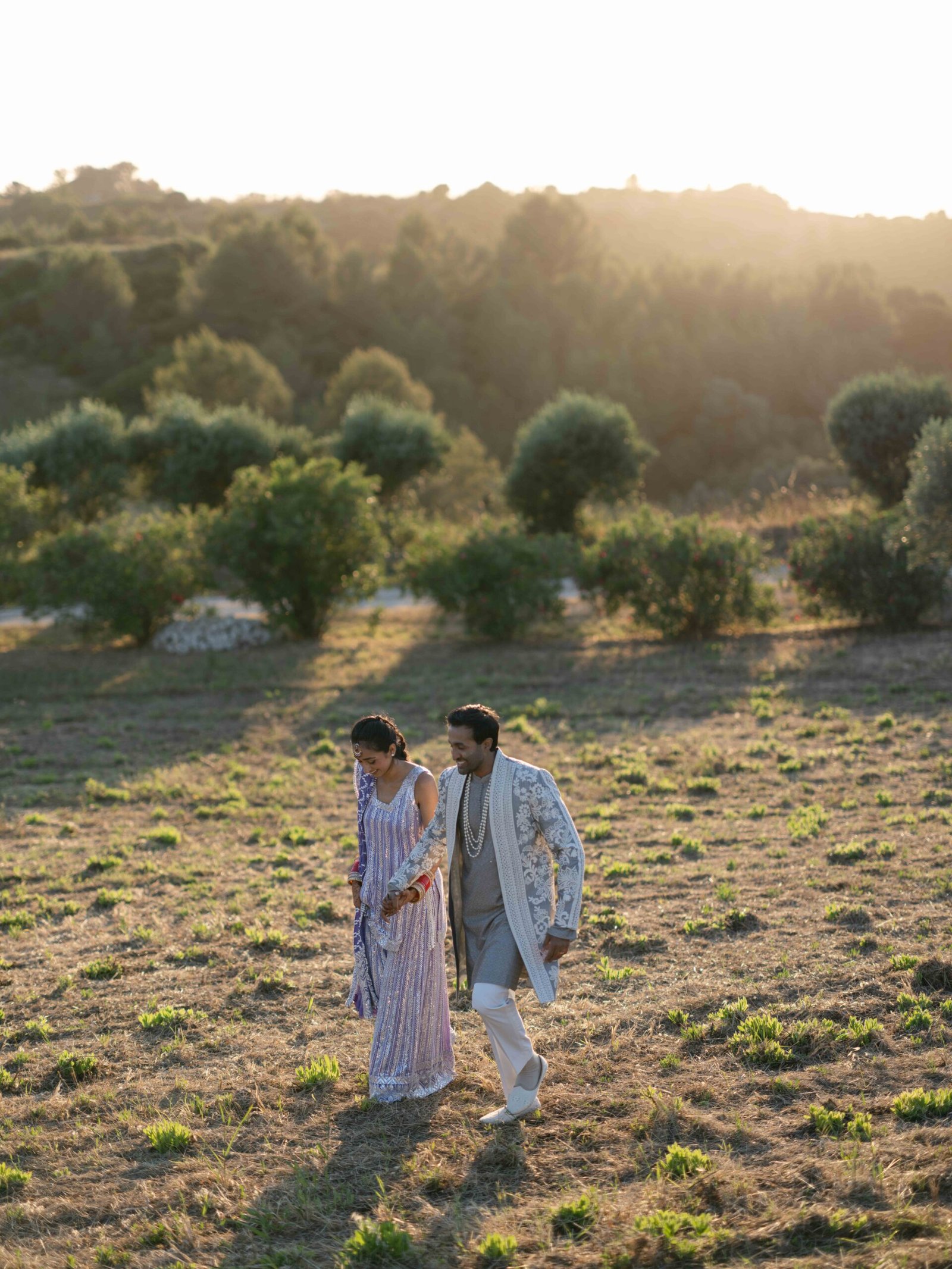 Indian couple in wedding attire in an olive grove near Lisbon at golden hour
