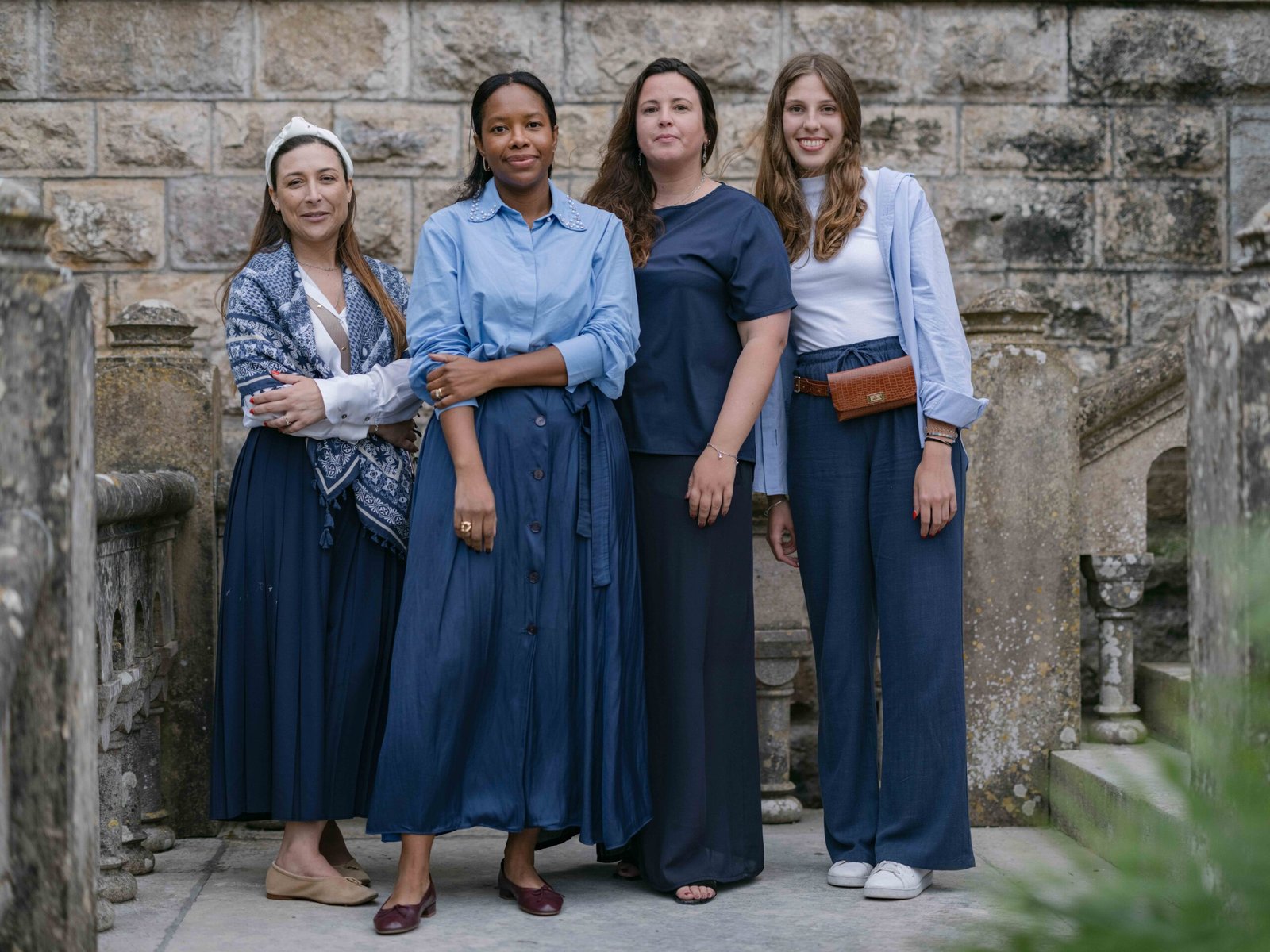Wedding guests in denim on a stone staircase in Lisbon, soft evening light