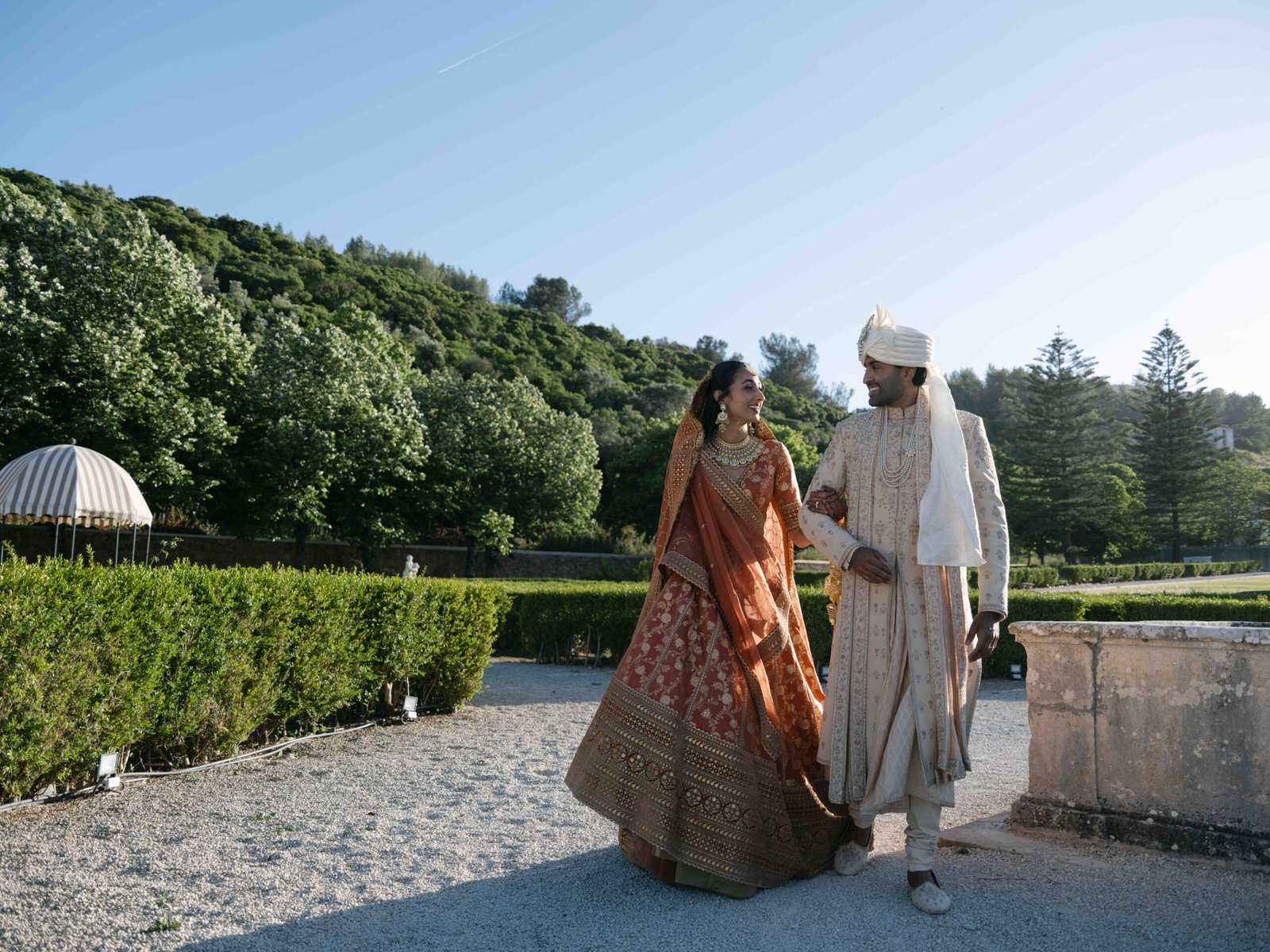 Indian couple in the gardens of a Lisbon estate, the bride in a rust lehenga at golden hour