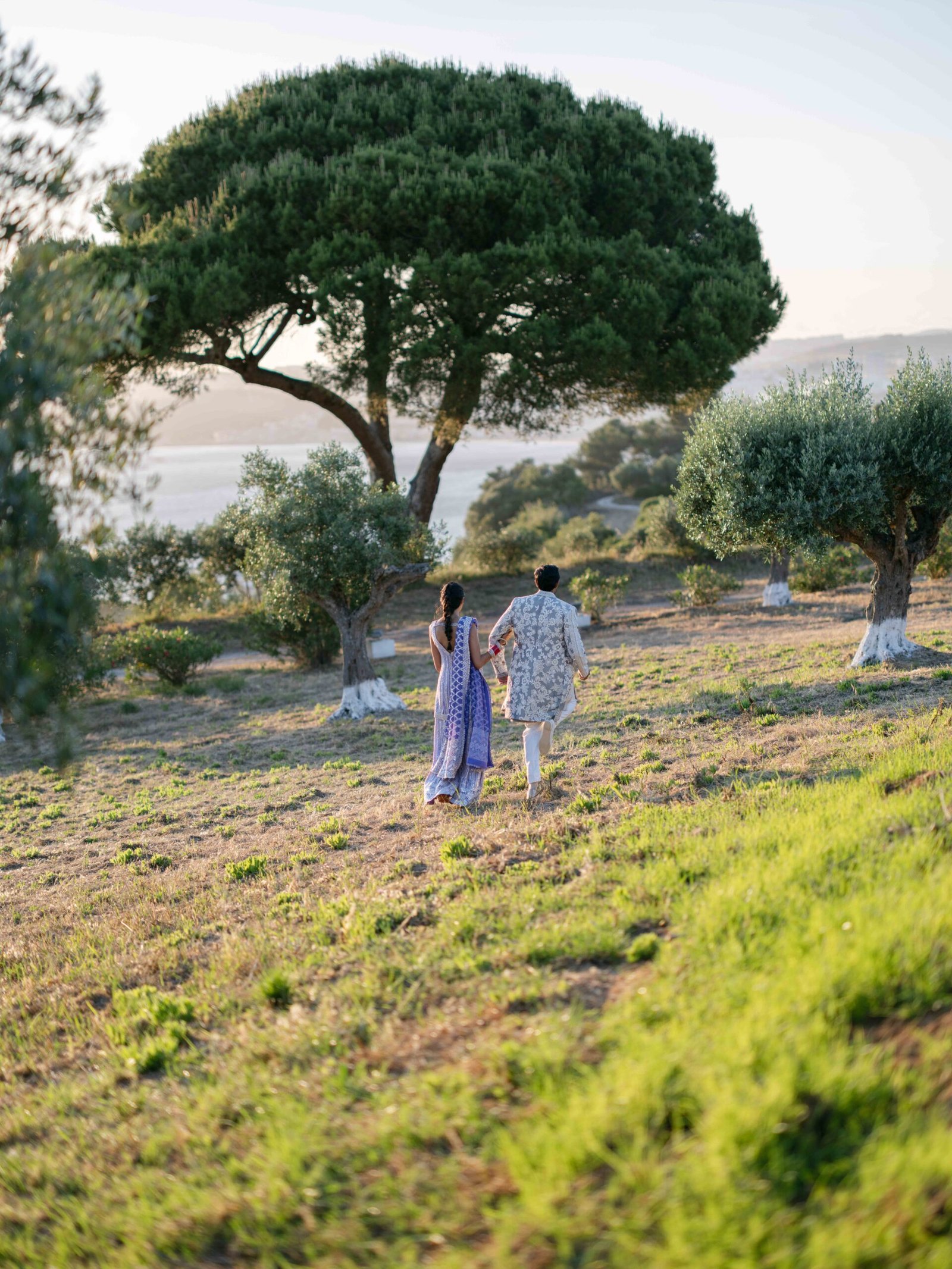Couple in an olive grove overlooking the coast near Lisbon at golden hour