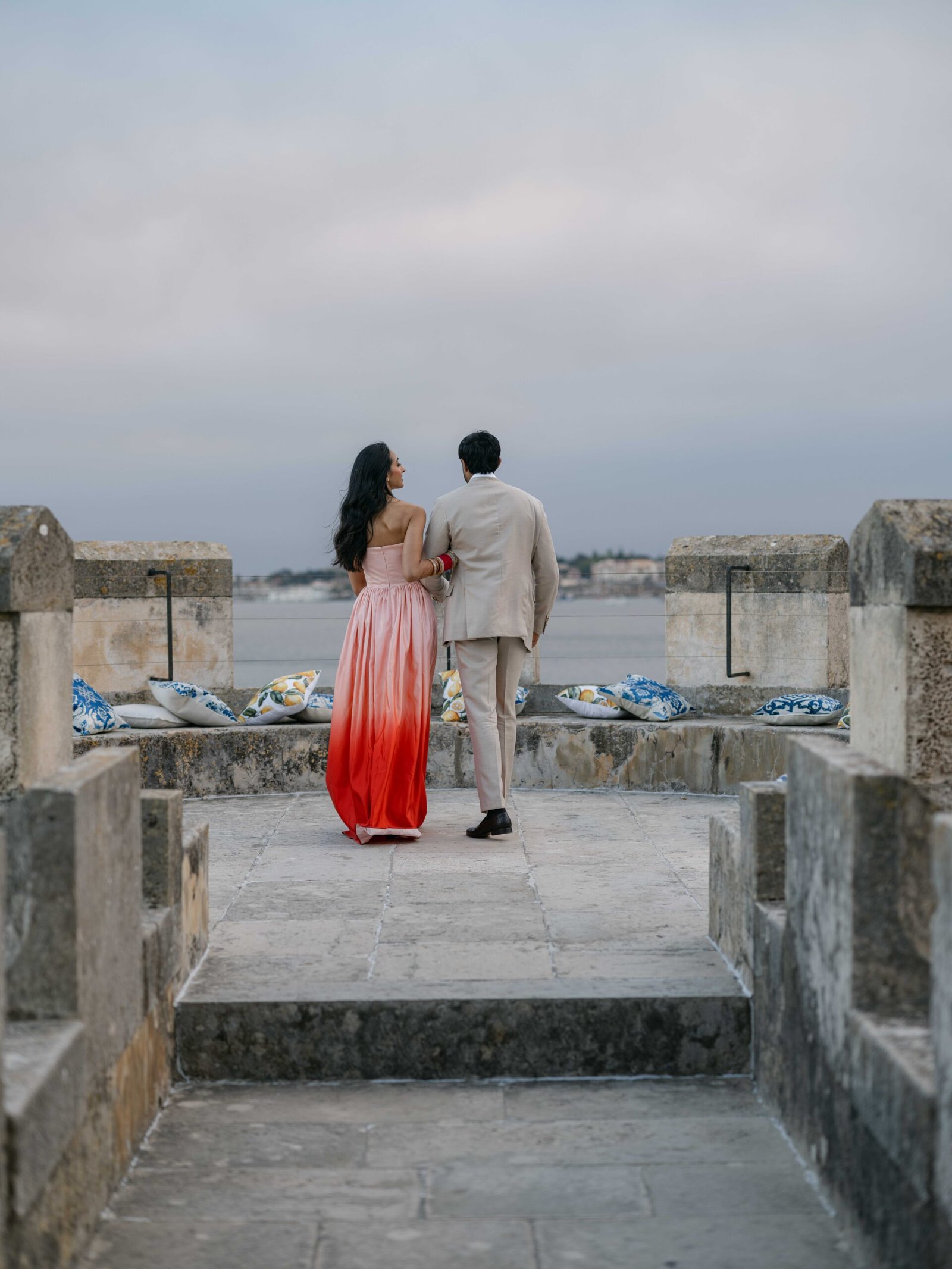 Couple on a stone terrace in Lisbon, the bride in an ombré gown at blue hour
