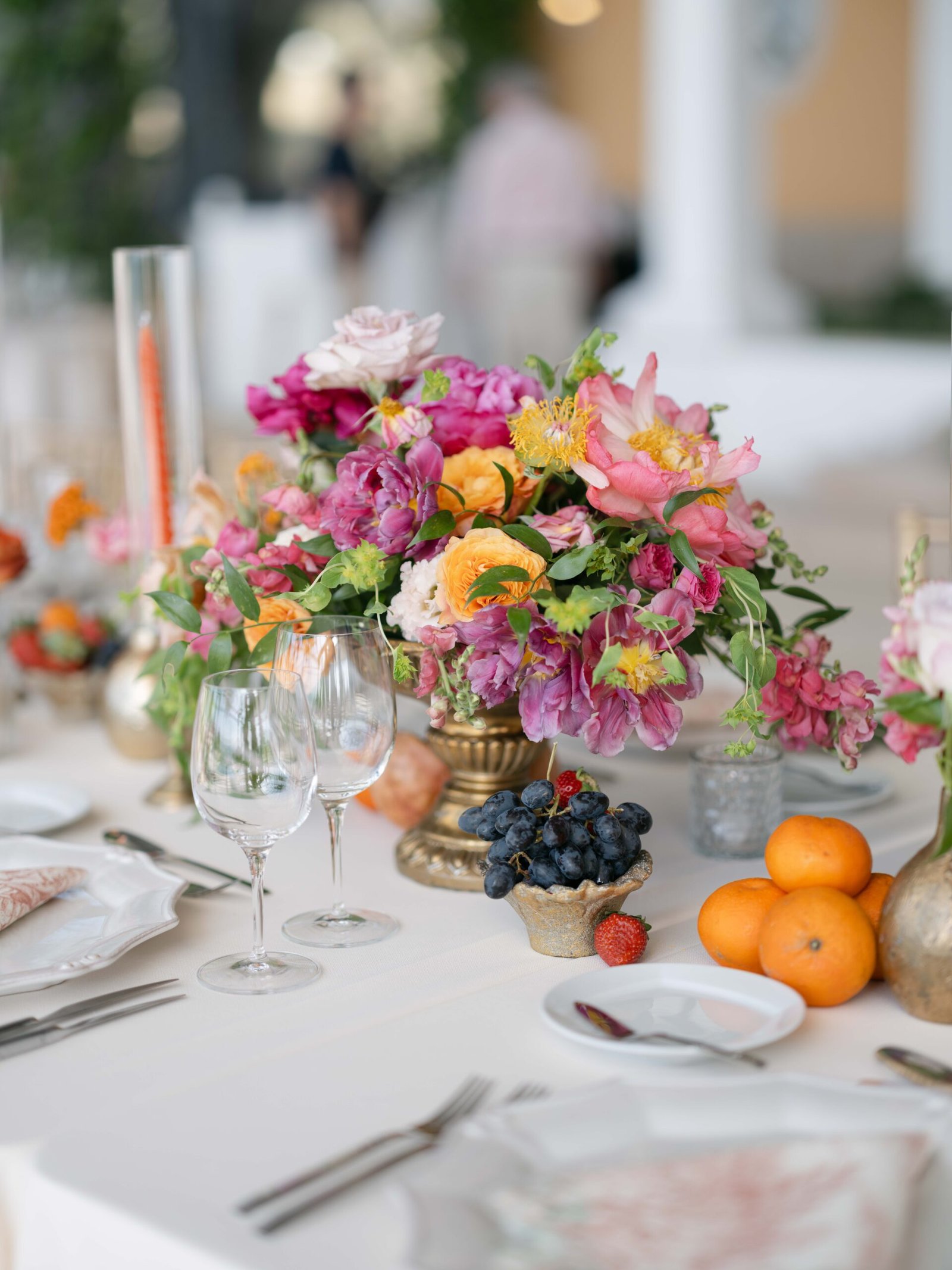 Reception tablescape with citrus, berries and vibrant flowers at an Indian wedding in Lisbon