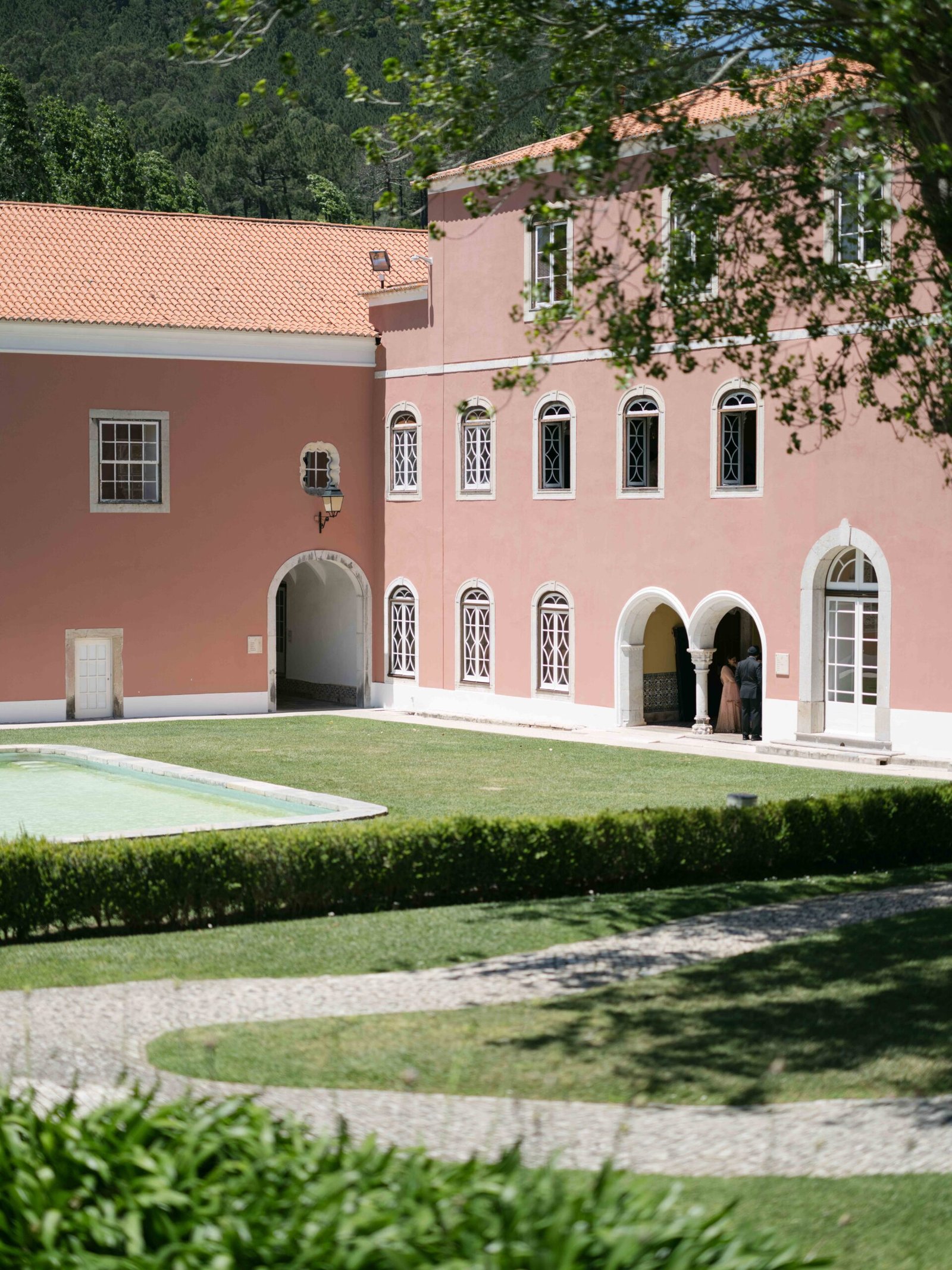 Pink manor house courtyard and garden in midday sun, Indian wedding venue near Lisbon