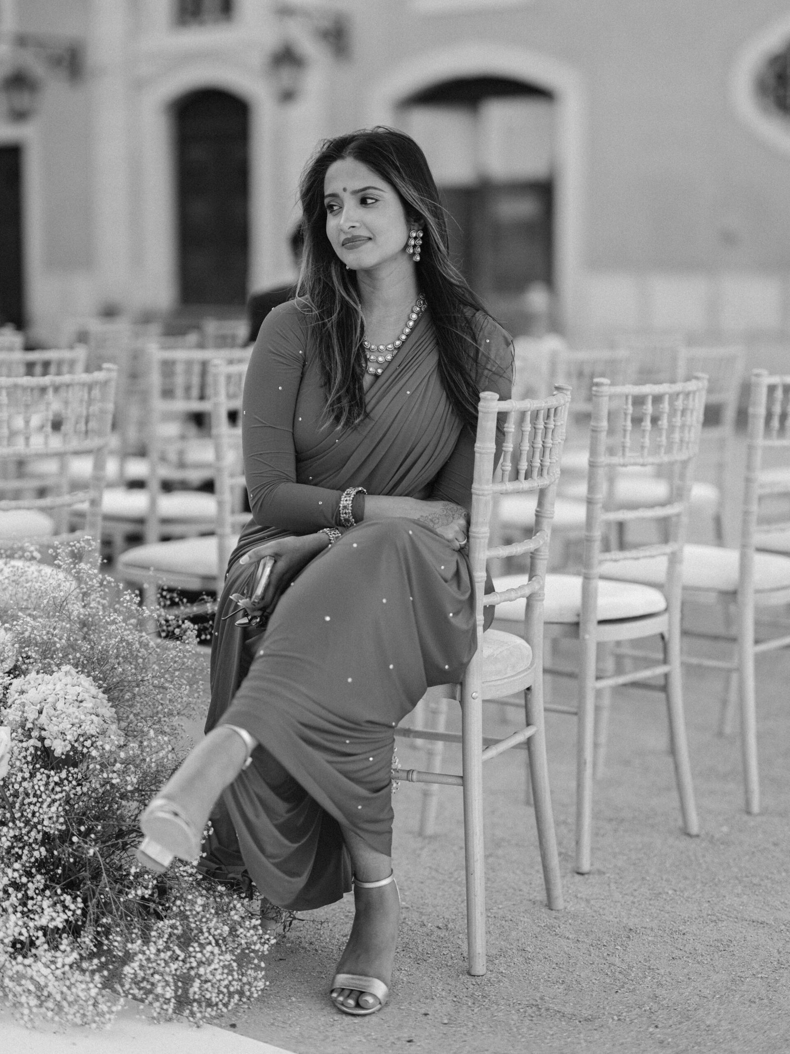 Guest in a saree among chiavari chairs at an evening wedding ceremony in Lisbon