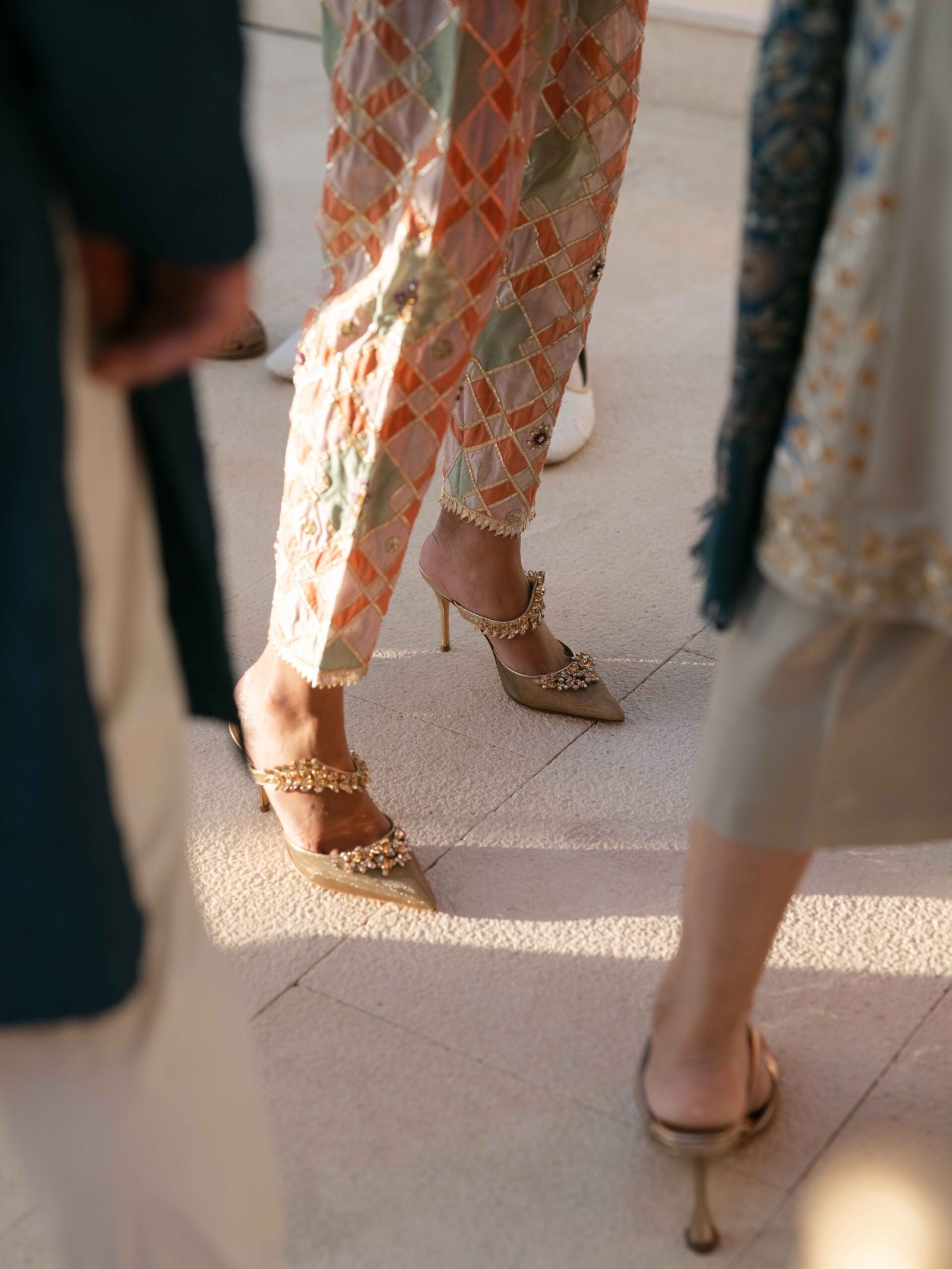 Embellished heels of wedding guests on a sunlit terrace in Lisbon