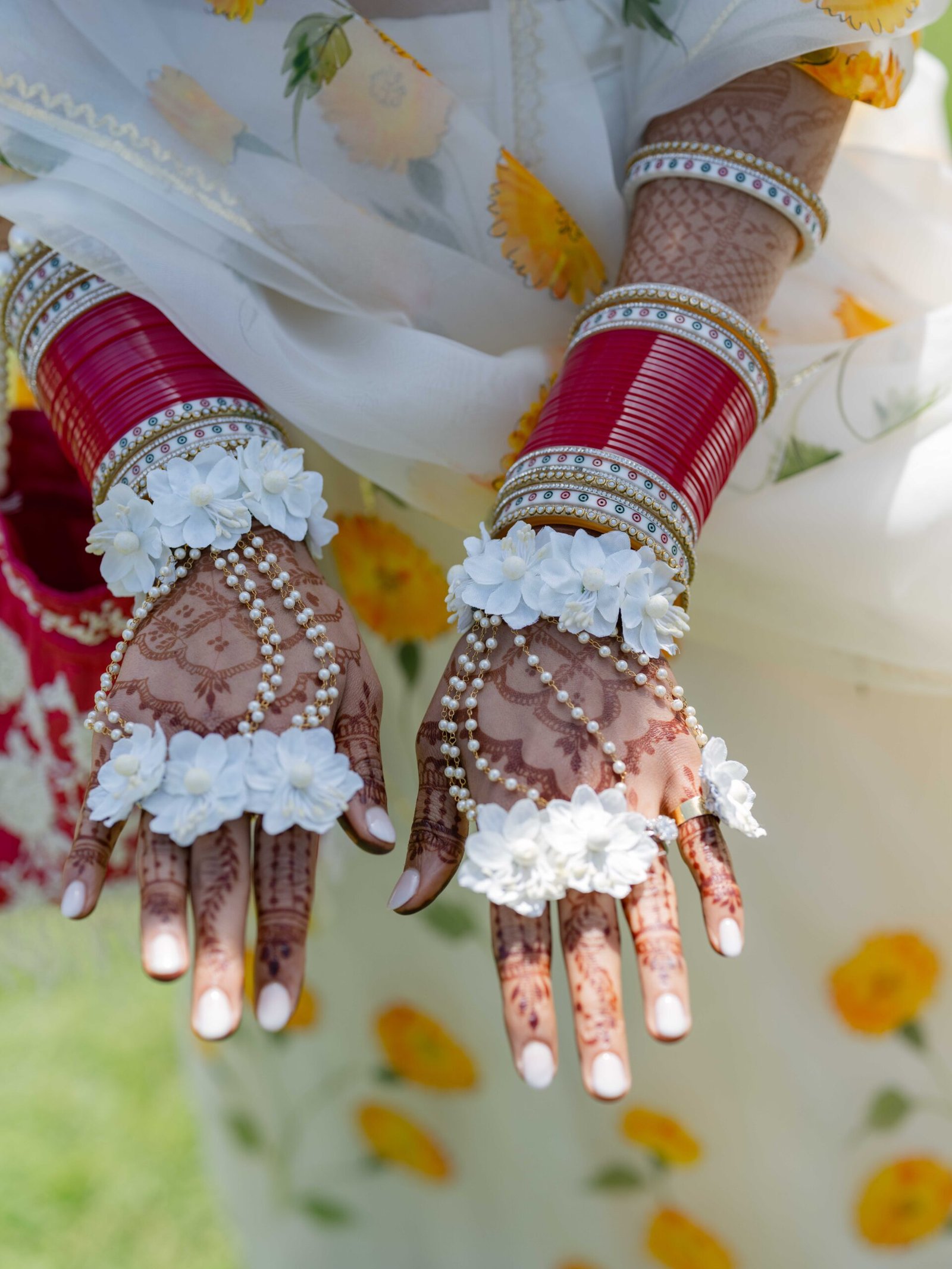 Bride's henna hands with red bangles and floral bracelets, Indian wedding in Lisbon