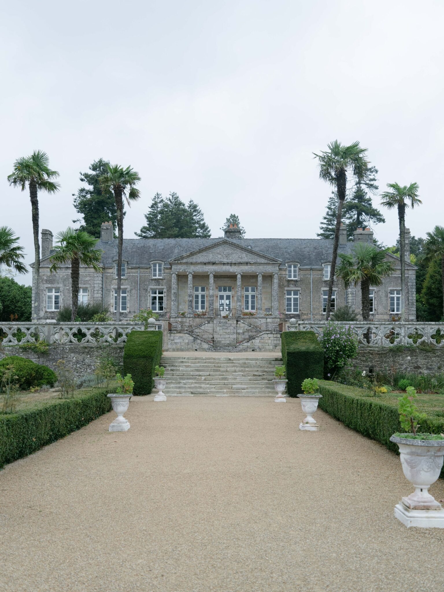 Gravel allee lined with clipped topiary at an Orangerie de Lanniron wedding venue in Brittany